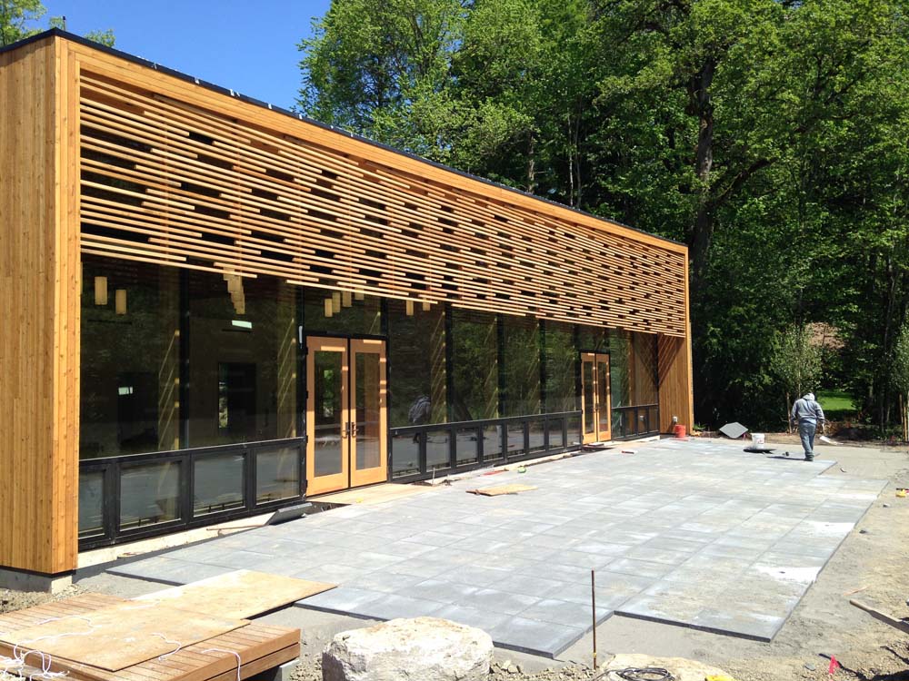 Nordia House's glass front under a wall of horizontal cedar slats, with tall trees behind